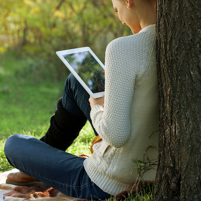 Lady relaxing at park with iPad