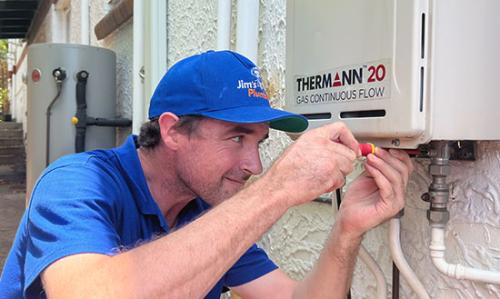 Plumber working outside on a Thermann continuos flow water heater