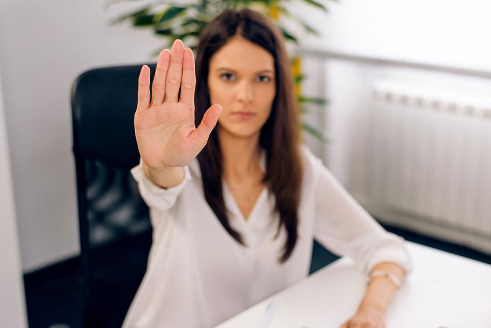 Lady at desk putting hand out to say stop