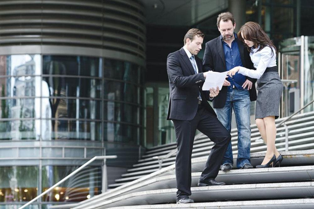 Professionals talking on steps outside office