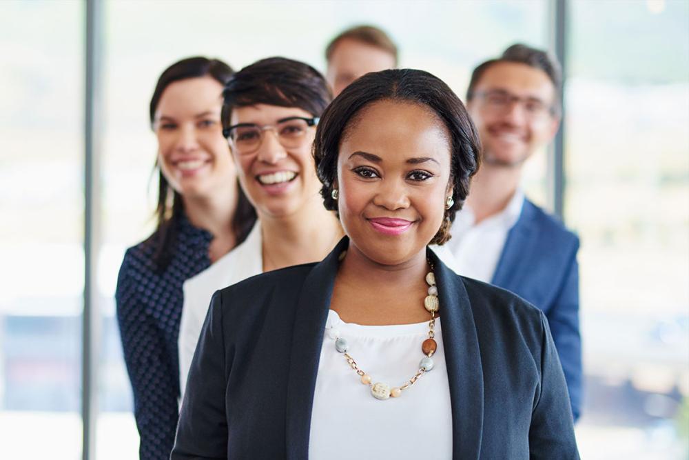 Group of professionals lined up behind a black lady