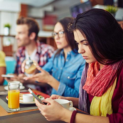 Girl on phone with group of people in background