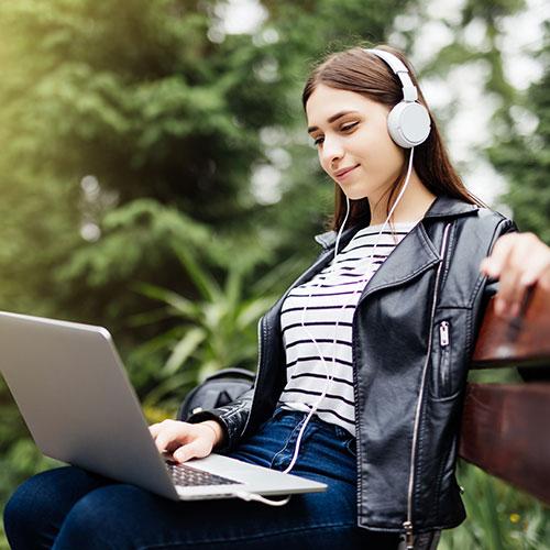 Lady outside listening to headphones