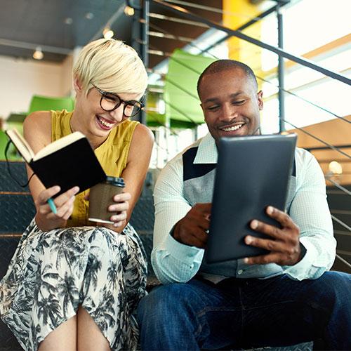 Man and woman on stairs watching laptop