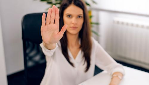 Lady at desk putting hand out to say stop
