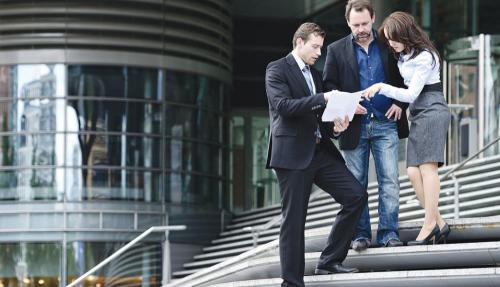 Professionals talking on steps outside office