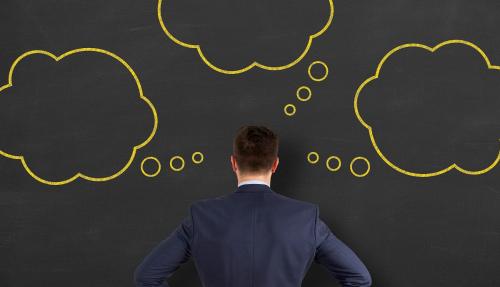 Man facing large chalkboard with speech bubble drawn in chalk