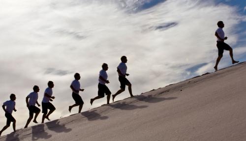 People walking up sandhill with clear leader