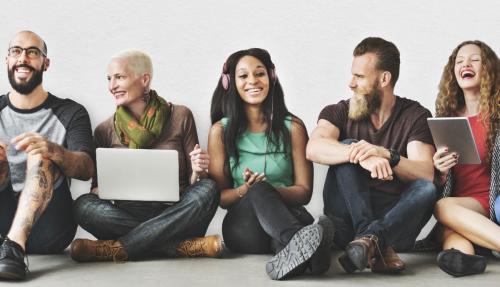 Young people sitting together on their laptops